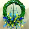 Blue and yellow floral wreath on a black easel