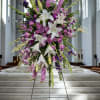 Large purple and white floral standing arrangement on an easel