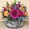 Bright mixed bouquet with pink gerbera, roses, and lilies in a glass vase