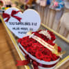 Heart-shaped box of red roses with a birthday message card and ribbon