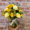 Yellow and cream bouquet in a glass vase with a twine tie