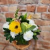 Bouquet of yellow gerbera daisies and white carnations in a glass vase