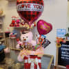 Gift arrangement with heart balloons, a teddy bear, and assorted chocolates