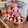 Pink plush toy with a rose and chocolate gift box arrangement