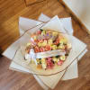 Bouquet of pink and yellow roses with a jeweled crown and ribbon