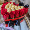 Heart-shaped box of red roses and gold-wrapped chocolates with a black ribbon
