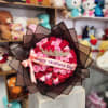 Bouquet of red and pink roses with a crown and Mother's Day ribbon