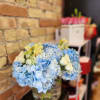Blue hydrangea bouquet with white roses in a glass vase