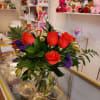Bouquet of red roses and purple filler flowers in a glass vase