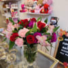 Bouquet of red roses, pink alstroemeria, and carnations in a clear glass vase