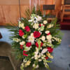 Standing floral spray with red and white flowers and palm fronds