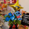 Blue roses with a plush Stitch and gold star balloon in a gift box