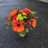 Bright orange and pink mixed bouquet in a glass vase