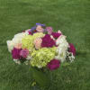 Colorful bouquet of roses, hydrangeas, and carnations in a glass vase