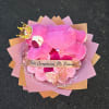 Pink teddy bear on a bouquet of pink roses with a birthday ribbon