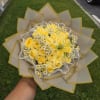 Yellow rose bouquet with small white daisies wrapped in beige paper