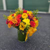 Bright mixed bouquet of red roses and yellow flowers in a glass vase