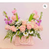 Pink roses and white daisies in a pink woven basket