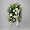White floral standing spray with roses and lilies on an easel