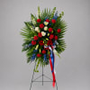 Standing floral wreath with red, white, and blue flowers on an easel