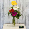 Colorful gerbera daisies arranged in a clear glass vase