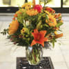 Orange and yellow mixed bouquet in a clear glass vase