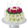 Round floral cake with candles and pink, white, and green flowers