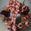 Floral wreath with pink and burgundy roses and a plaid ribbon bow