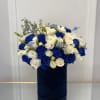 Blue and white rose bouquet in a dark cylindrical box