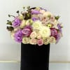 Bouquet of pastel roses, orchids, and white dahlias in a black box