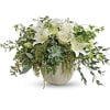 White roses and lilies in a round vase with trailing greenery