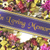 Purple memorial ribbon over a colorful floral wreath