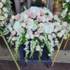 Large pastel floral arrangement with pink and white roses and cascading white blooms