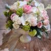 Pink and white floral arrangement in a white pedestal vase