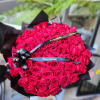Large bouquet of hot pink roses wrapped in black paper with ribbon