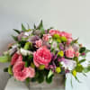 Pink roses and mixed blooms arranged in a wooden box