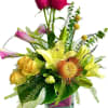Mixed bouquet in a clear glass vase with lilies, roses, and pink blooms