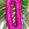 Pink flower lei on large green tropical leaves
