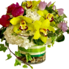 Bouquet of yellow orchids, pink tulips, and white flowers in a glass vase