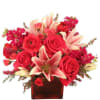 Red roses and pink lilies in a red glass vase