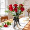 Bouquet of red roses in a clear glass vase with a black ribbon
