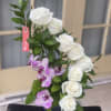 White roses and purple orchids in a square vase