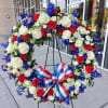 Memorial Wreath, approximately 25&rdquo; wide. Stands on a tall Easel. Red White