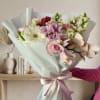 Soft pink gerbera daisies and creamy roses mingle with lavender orchids and
