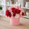 Pink and red rose bouquet in a pink cylindrical box