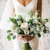 A timeless and elegant bridal bouquet featuring premium white roses, delicate blooms