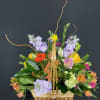 Mixed flower basket with a bird decoration and tall curly branches