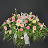Pink and white floral spray with lilies, roses, and daisies