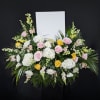 Floral standing spray with pink and yellow roses and white blooms