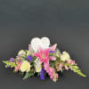 Sympathy floral arrangement with pink lilies and cream roses around a heart memorial plaque